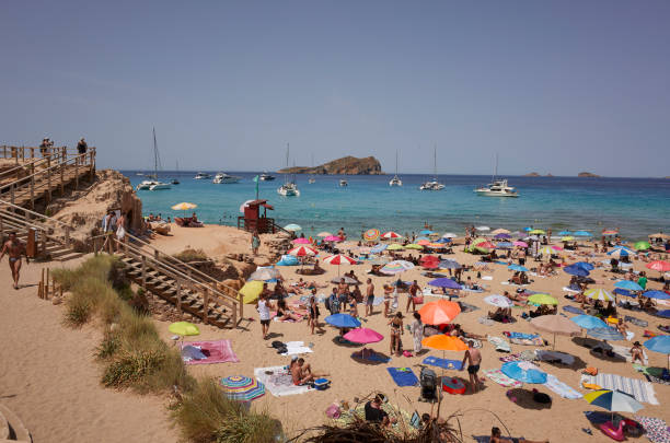 Ibiza, Spain - June 15, 2022 : Tourists sunbathing at Platges de Comte in Ibiza