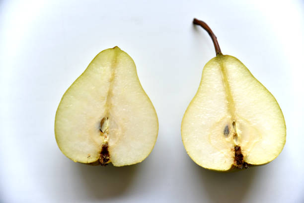 Sliced green pear in half on a white background. Nature background.