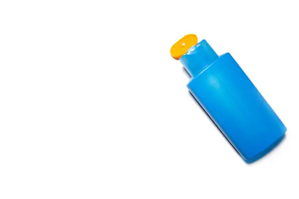 A blue bottle of sunscreen isolated on a white background.