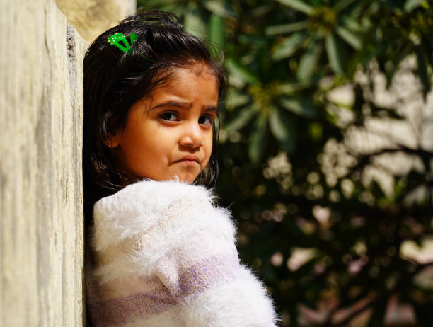 a sad little girl hide face from family