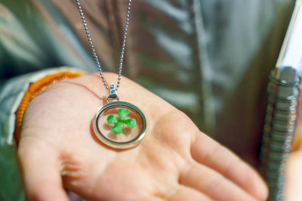 Round talisman with chetrehlaf clover inside on the child's hand