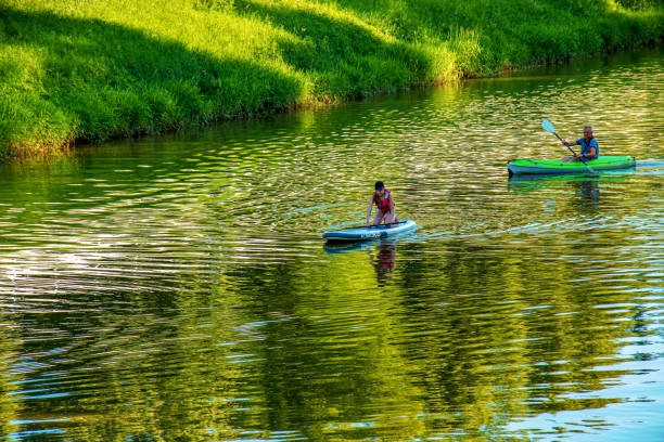 A young girl and a middle-aged man are sailing in different canoes on the Nitra river. stock photo