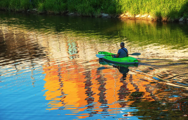 A middle-aged man is sailing in a canoe on the Nitra river. stock photo