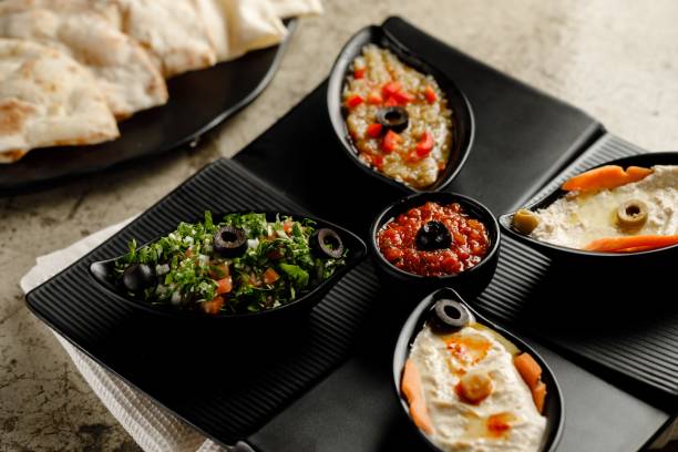 istock Mixed Mazzaa ssorted breakfast Tabouleh Salad, Hummus, and bread served in a dish isolated on grey background side view fast food 1406565102