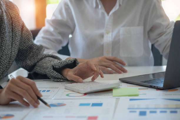istock Team of business women use calculators and graph analysis computer laptop tablets to plan marketing strategies and make profitable investments for the company. 1406565165