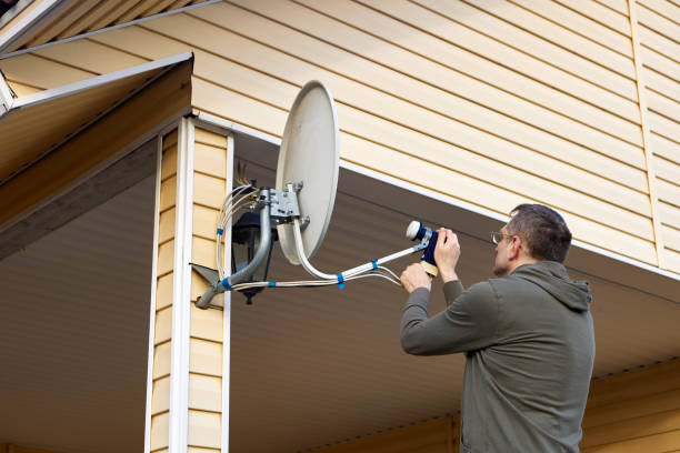 istock Repair TV satellite dish, homeowner tightens  connecting nuts. 1406568142