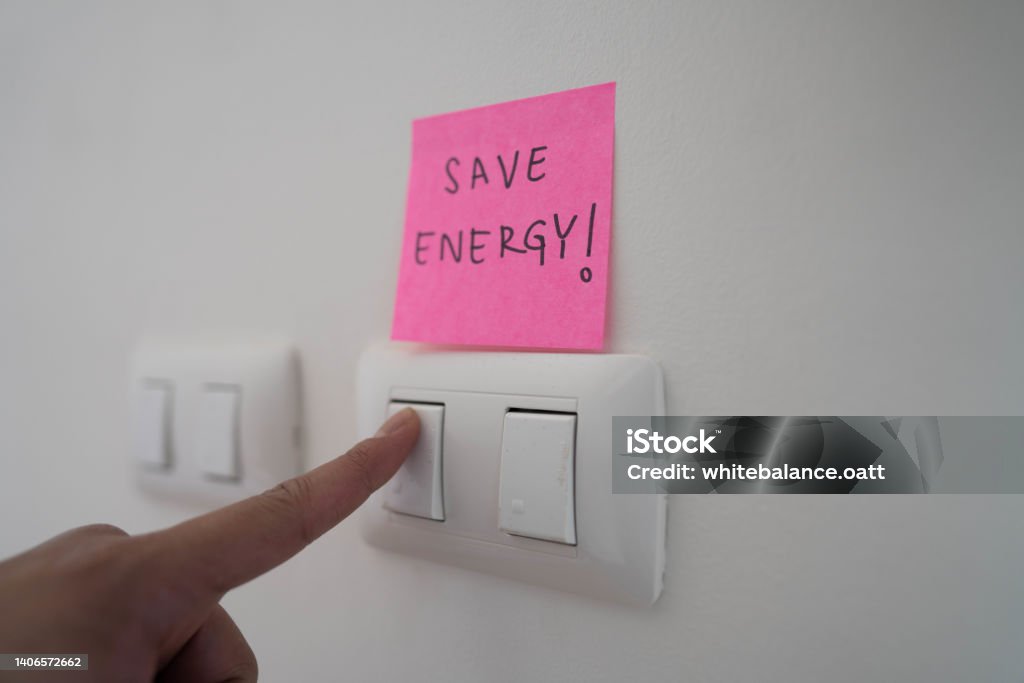Please turn off a light when not in use. Employee turn off a light switch for save energy in sustainable office. Turning On Or Off Stock Photo