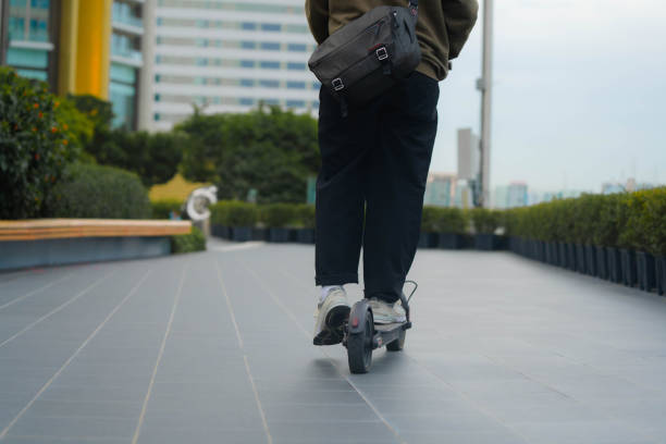 istock Businessman riding e-scooter through financial district. 1406572723