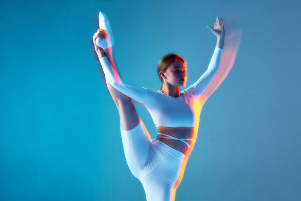 istock Young ballerina training, dancing with raised leg. Slim girl performs modern ballet dance. Motion blur, long exposure 1406572907