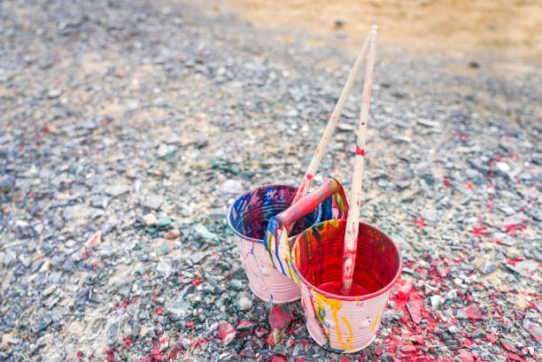 Buckets of colors on ground, Paint cans with paintbrushes, Blue and red colors in the pots