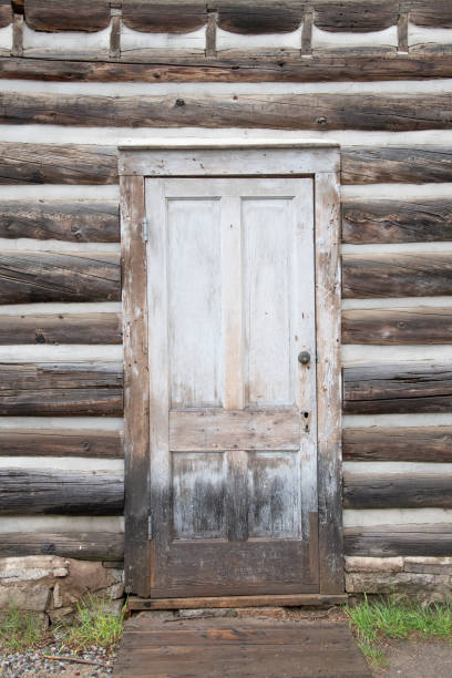 istock Old exterior door and wall on log house in ghost town 1406574844