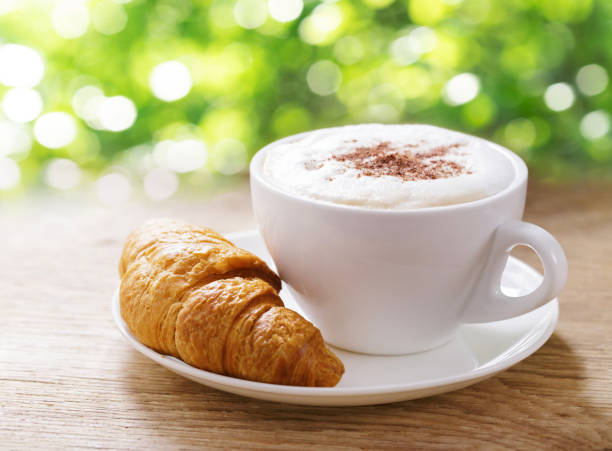 Cup of cappuccino coffee and croissant