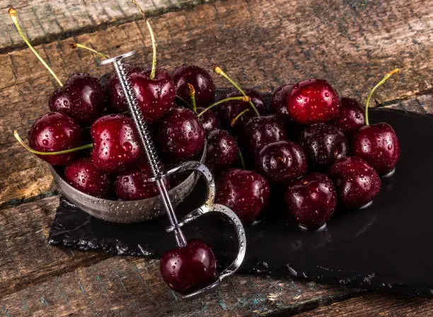 Cherry pitting tool. Juicy ripe cherries