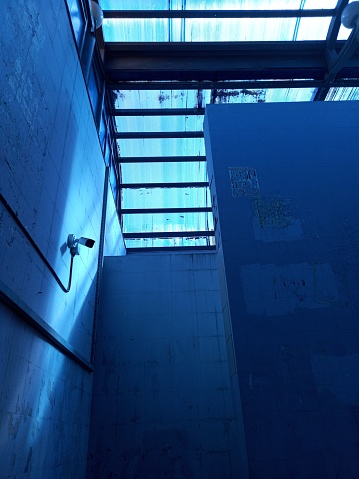 Surveillance Camera in corridor illuminated with blue light underground