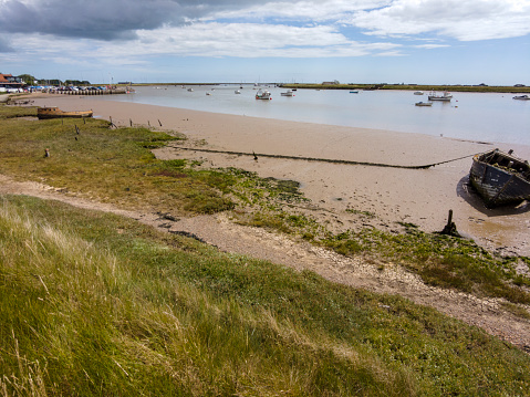 Old wrecks appear on the bank of the river Alde at low tide near Orford Ness in Suffolk