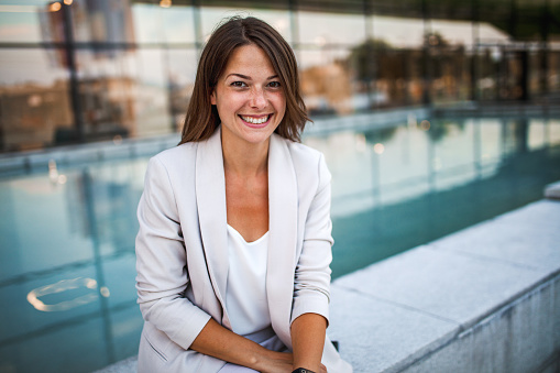 Portrait of smiling business woman in front of an office building