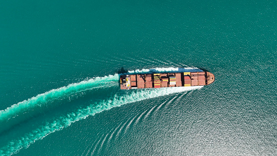 A fully stocked cargo ship heading out to sea.