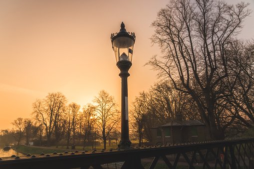 Old vintage lantern lamp post on the sunset sky background