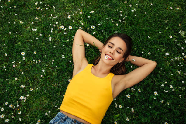 istock Smiling young woman lying on grass 1406583978
