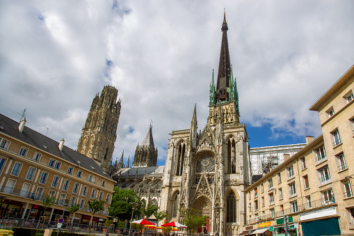 The famous Rouen Cathedral (Cathedral Notre Dame de Rouen)   -  amazing architecture of medievak France .People in distance sirrinf in cafe and walking