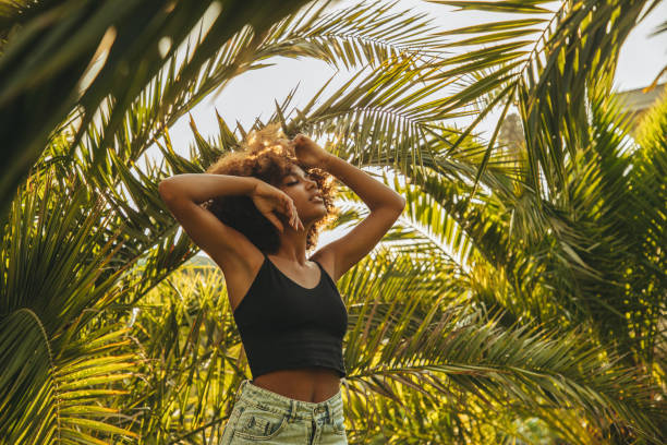 istock Pretty young afro woman among palm trees 1406584250