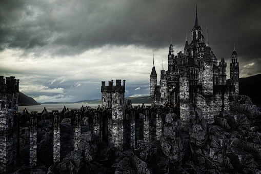 Dark fantasy medieval castle in rocky landscape by a lake with moody grey clouds. 3D illustration.