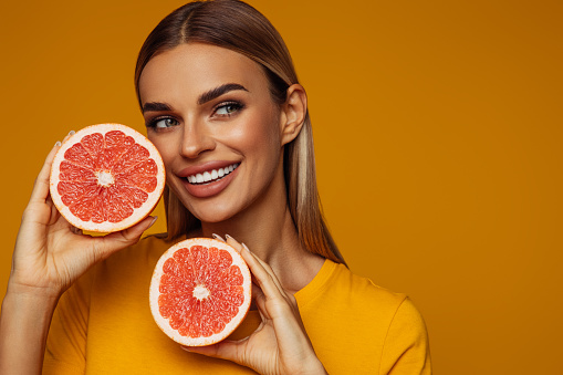 Portrait of girl holding red grapefruit