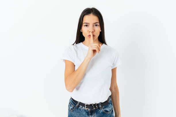 istock Young woman asks for silence with her finger to her lips 1406590658