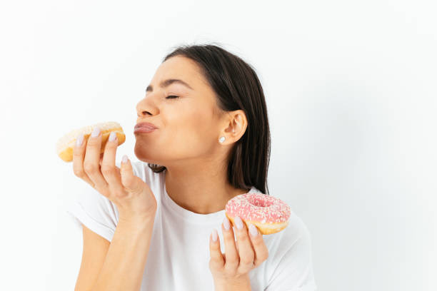 istock Woman eating doughnuts, enjoying dessert 1406590681