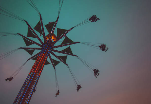 fair swing ride al crepuscolo tonico con un filtro instagram vintage retrò - ferris wheel wheel blurred motion amusement park foto e immagini stock