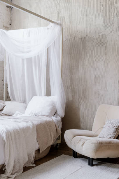 istock Armchair standing near boho bed with cushions, pillows and bedding 1406593137