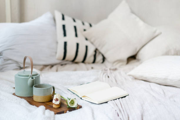 istock Open book at comfort bed close to serving tray with breakfast 1406593165