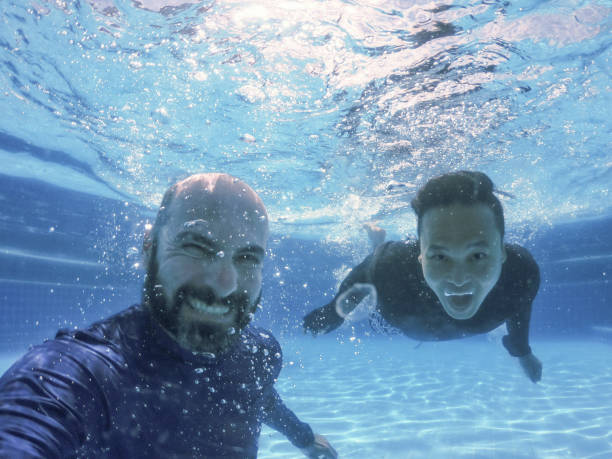 istock Gay couple smiling underwater. 1406593495