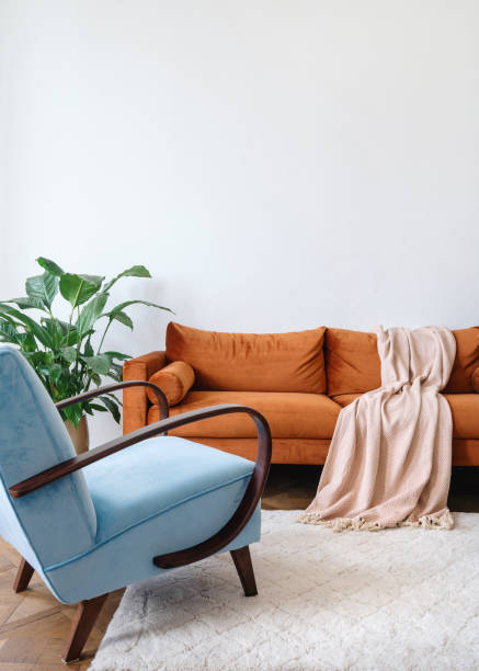 istock Ergonomic couch with plaid and armchair in bright apartment 1406593530