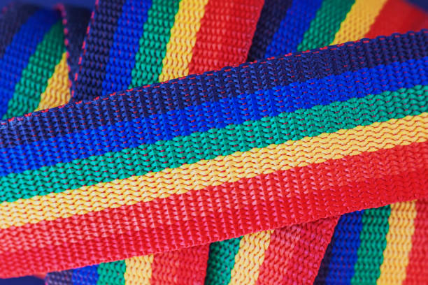 pile de rubans textiles brillants, couleur arc-en-ciel, fond abstrait pour les moments lumineux de la vie - multi colored ribbon rainbow gay pride flag photos et images de collection