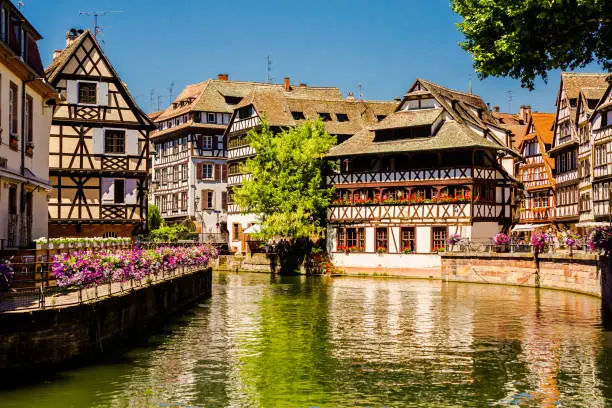 Alsace. Old ancient French city Strasbourg. Summer trip to France. European country. French architecture. Voyage. Warm sunny day. Travel destination. Street. Facade of houses. Il river