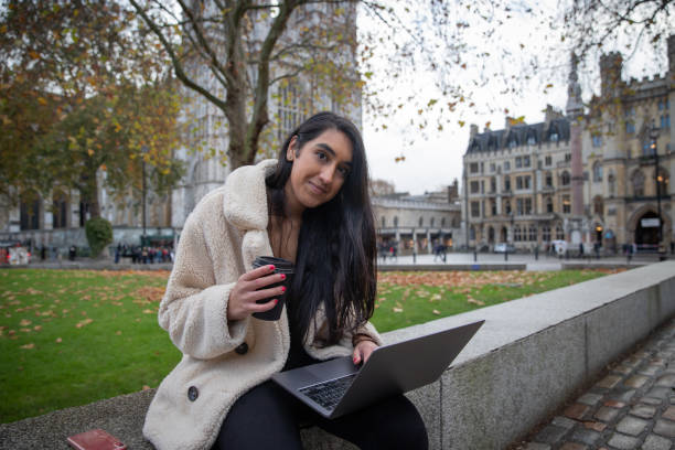 istock A freelancer girl works with her laptop outdoors while drinking coffee. 1406605229