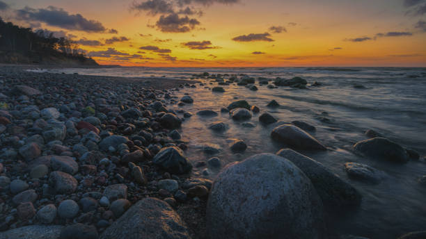 istock Colorful sunset on the sea rocky shore 1406605686