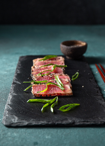Japanese food. Tuna tataki. Raw tuna sashimi on black board