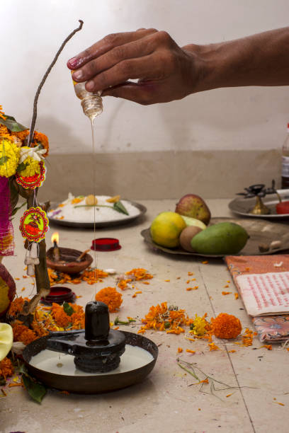 un prêtre hindou offrant du miel à shiva linga à l’occasion de la première fois qu’un individu entre dans sa nouvelle maison. graha pravesh entre dans la nouvelle maison. - soi bangla photos et images de collection