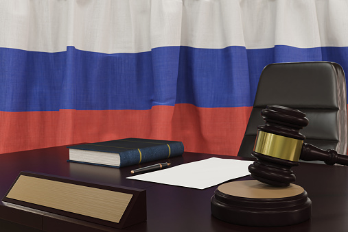 Law and justice concept,  gavel on a wooden desktop and the Russia flag on background. 3d render.
