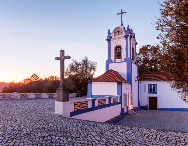 Partial view, at sunset, of the Ermida Nossa Senhora do Castelo in Coruche, Portugal, highlighting the bell tower. stock photo