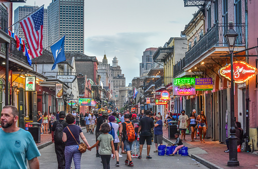New Orleans, LA, USA - June 30, 2022: Tourists enjoying a stroll down the famous Bourbon Street, New Orleans Louisiana. Bourbon Street is the center of nightlife in the French Quarter of New Orleans.