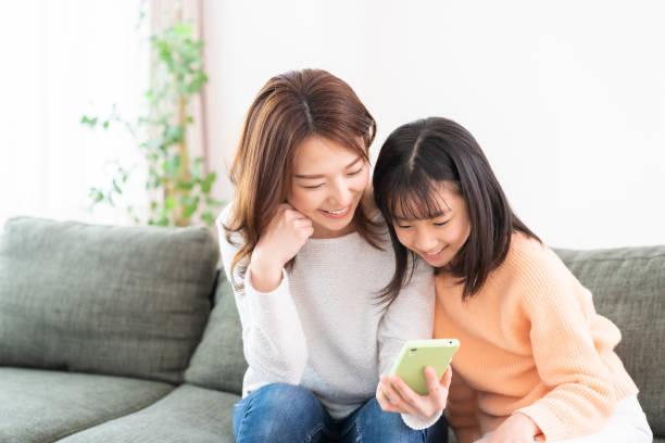 istock asian mother and daughter,smart phone 1406620780