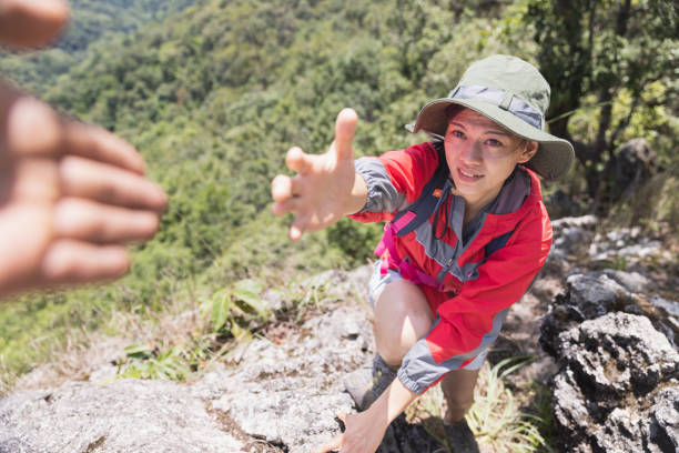 istock Two people climbing mountain and help, help and assistance concept 1406624420