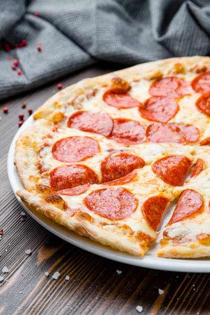 istock Pepperoni pizza on plate on wooden table 1406627802