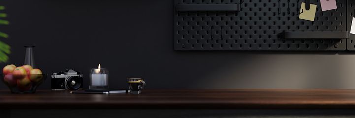 Modern dark and black home working studio design with accessories and copy space on dark wood tabletop against the black wall with pegboard. 3d rendering, 3d illustration