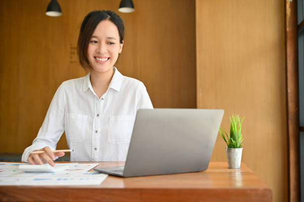 istock Pretty Asian businesswoman working at her desk, using notebook laptop. 1406629076