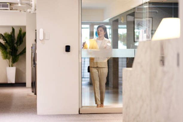 Asian business woman ready for work to office. Asian business woman with bag, reusable cup, and work permit getting into the office for work. walking into glass door stock pictures, royalty-free photos & images