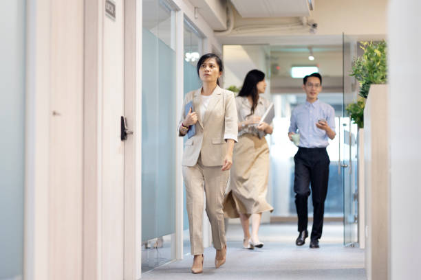 istock Asian businessmen walking on the hallway and discussing the working content. 1406630974